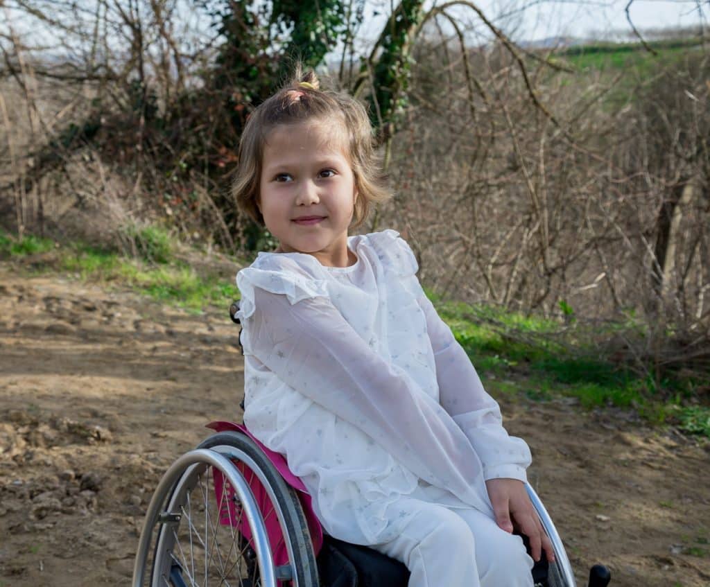 ילדה בכסא גלגלים מחייכת